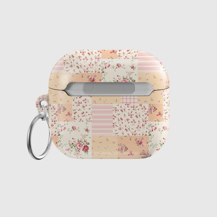AirPods case featuring a vintage patchwork design with pastel floral patterns, soft pink and beige tones, and a silver keychain—charming and protective earbuds cover with a cottagecore aesthetic.