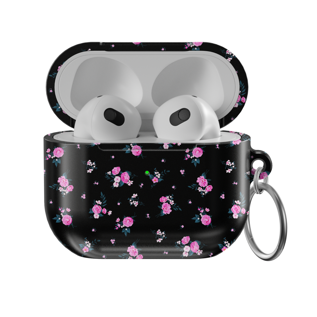 Glossy black AirPods case featuring scattered pink rose floral pattern with mini white accents, paired with a silver keychain—stylish and protective for music lovers on the go.