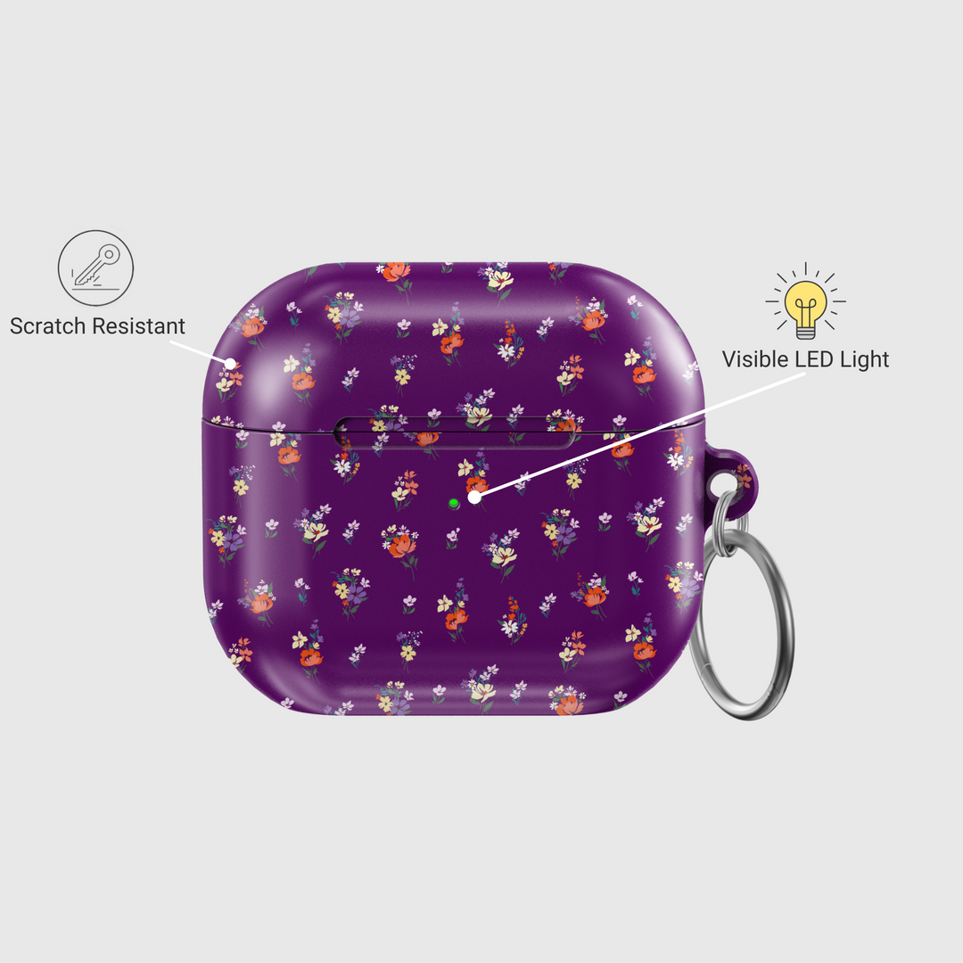 Glossy purple AirPods case with delicate mini floral bouquet pattern in red, orange, yellow, and white, complete with a silver keychain—perfect for a music lover with a soft spot for bold floral style.