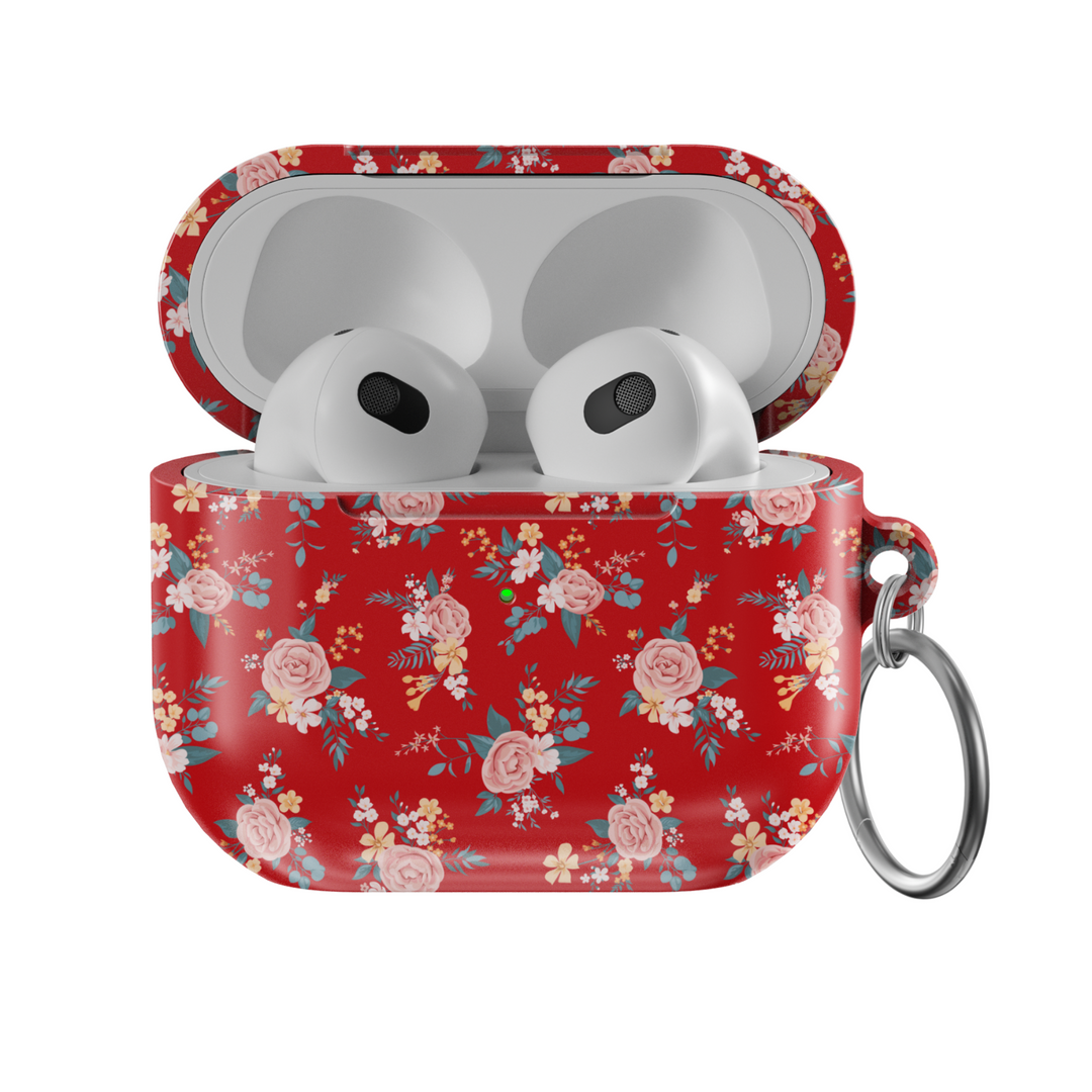 Glossy red AirPods case featuring delicate vintage-style floral print with soft pink roses and blue leaves, paired with a silver keychain—ideal for romantic, music-loving aesthetics.