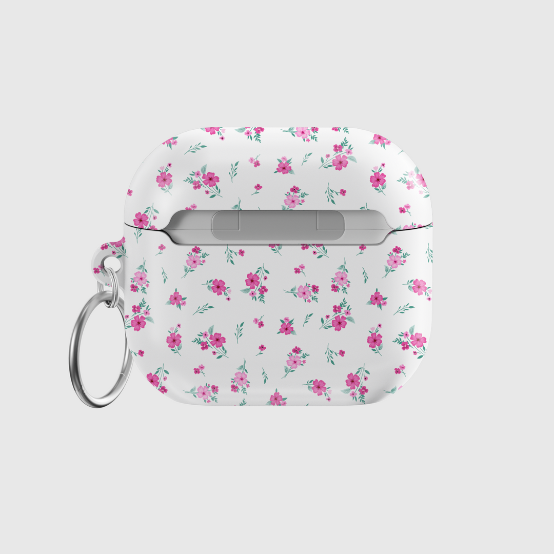 White AirPods case with tiny pink floral pattern and silver keychain, featuring a glossy finish—perfect for music lovers and feminine aesthetics.