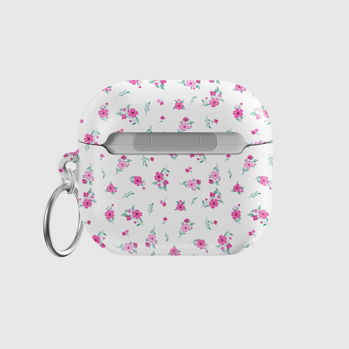 White AirPods case with tiny pink floral pattern and silver keychain, featuring a glossy finish—perfect for music lovers and feminine aesthetics.