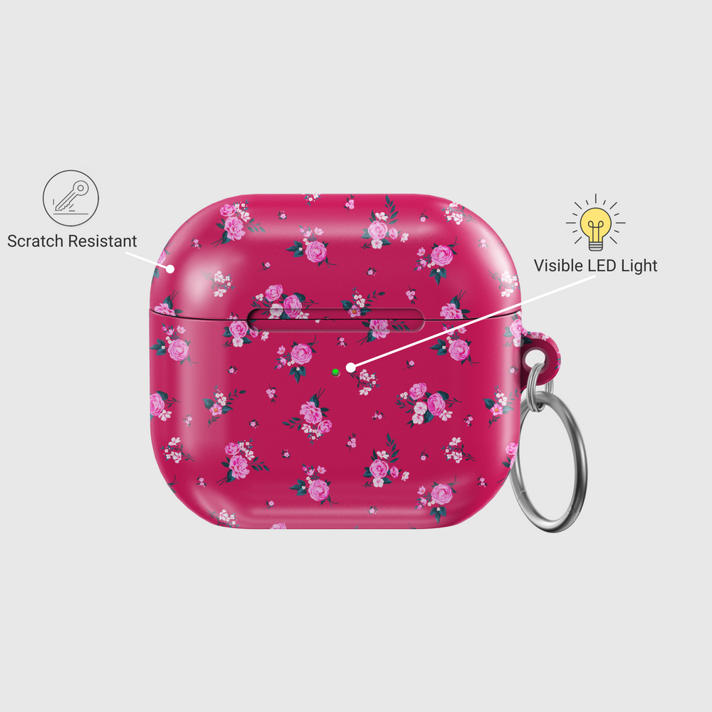 Glossy AirPods case in vibrant pink featuring scattered rose floral pattern and attached silver keychain, designed for music lovers who enjoy romantic and feminine styles.