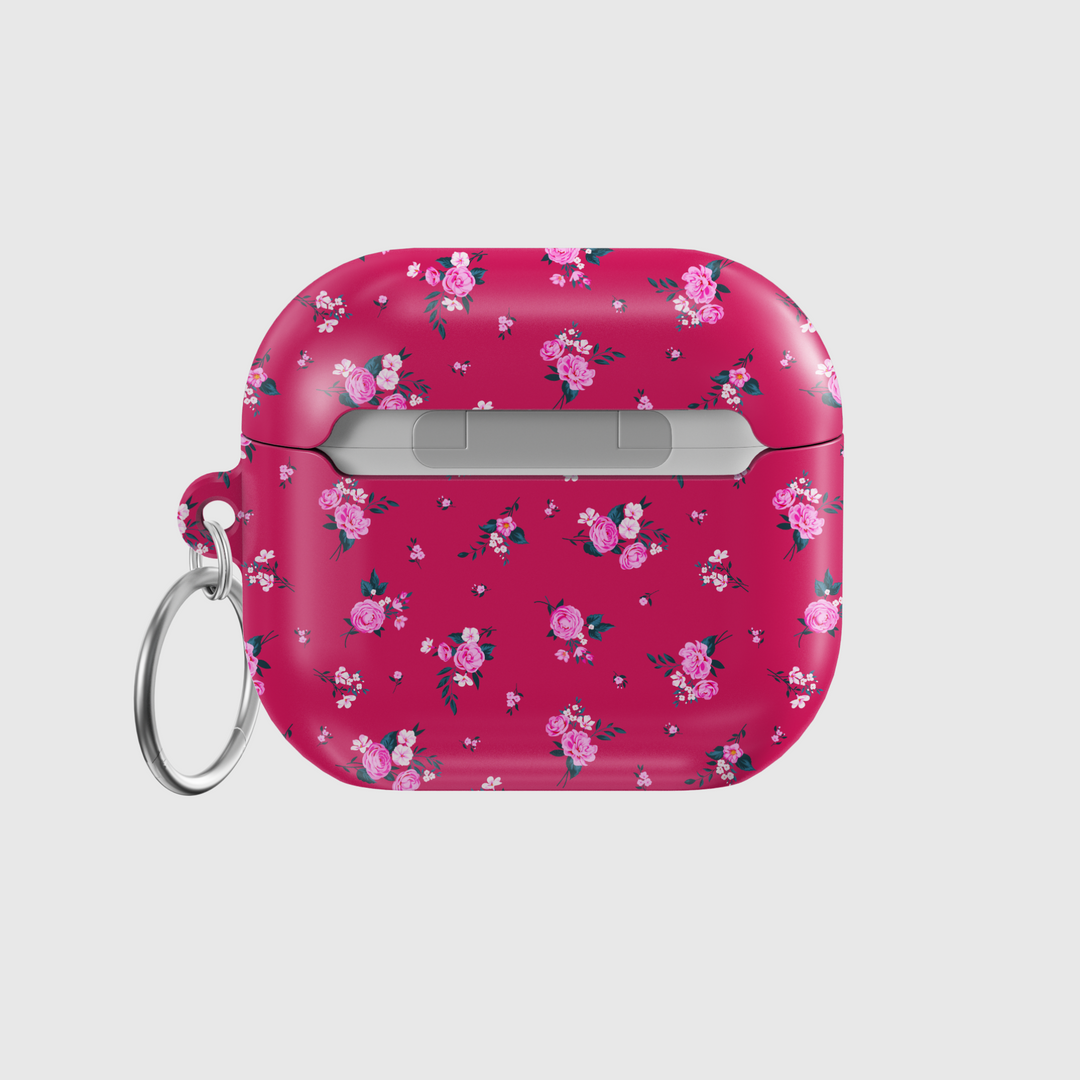 Glossy AirPods case in vibrant pink featuring scattered rose floral pattern and attached silver keychain, designed for music lovers who enjoy romantic and feminine styles.
