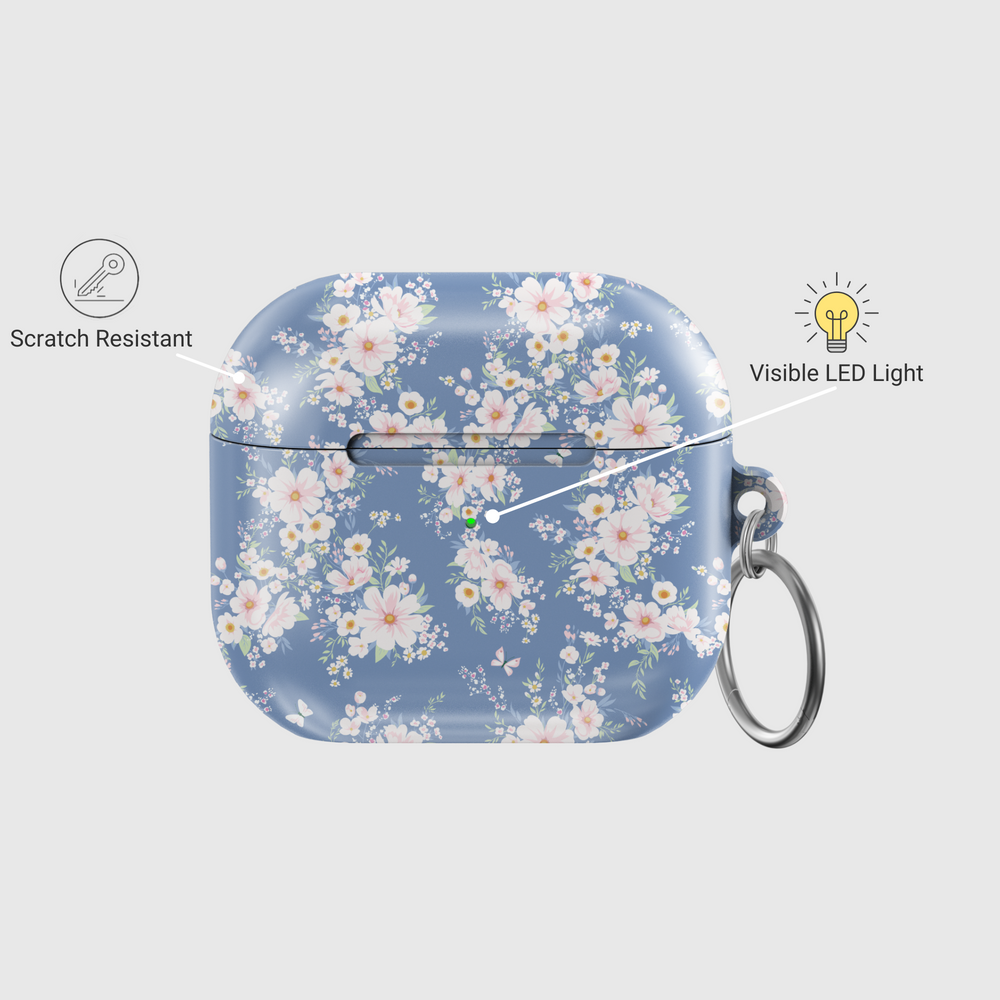 AirPods case with a soft blue background and delicate white and blush floral pattern, featuring a glossy finish and silver keychain, designed for music lovers who adore a romantic and vintage aesthetic.