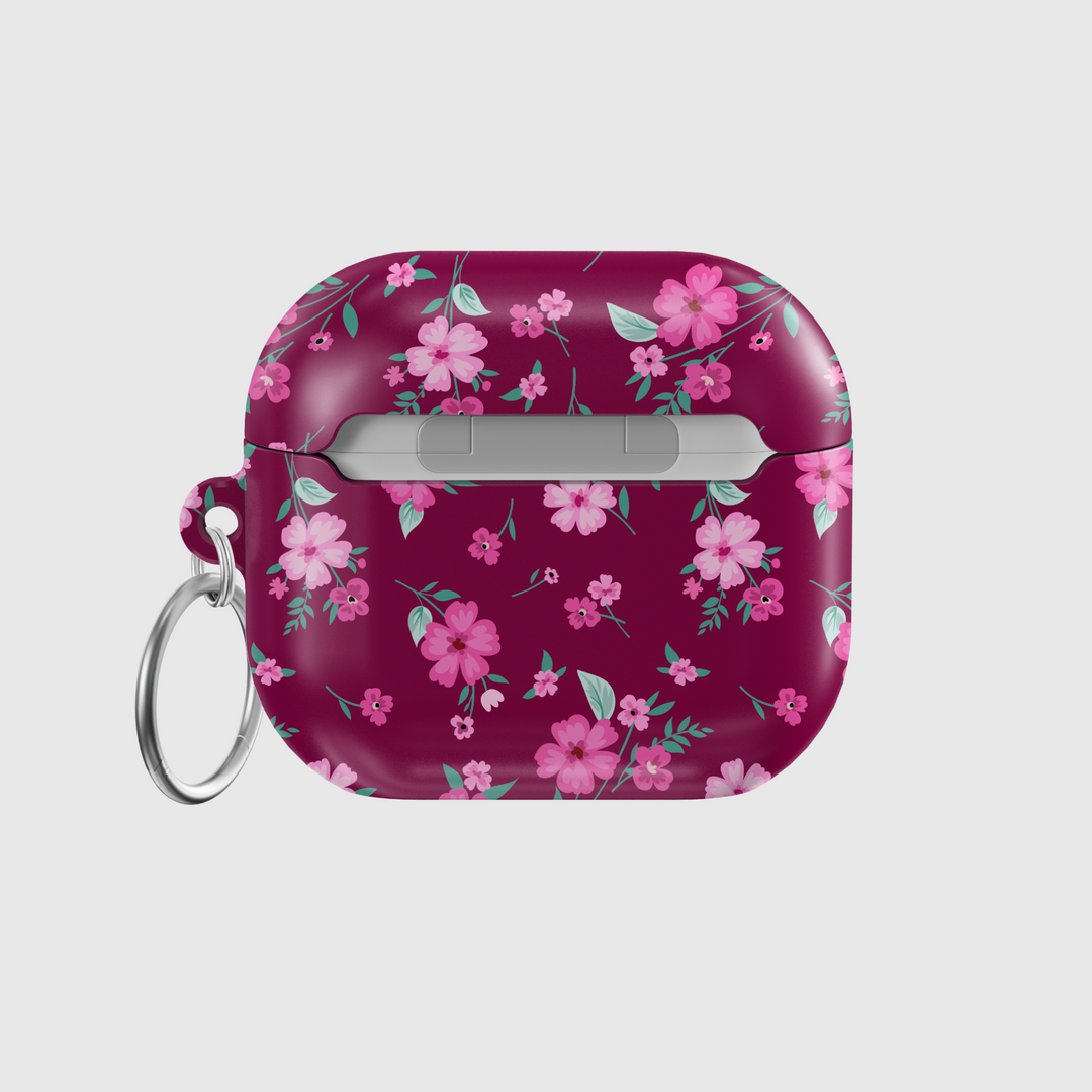 Glossy maroon AirPods case with pink floral design and keychain, perfect for music lovers looking for a stylish and protective accessory for their AirPods Pro or AirPods 3.