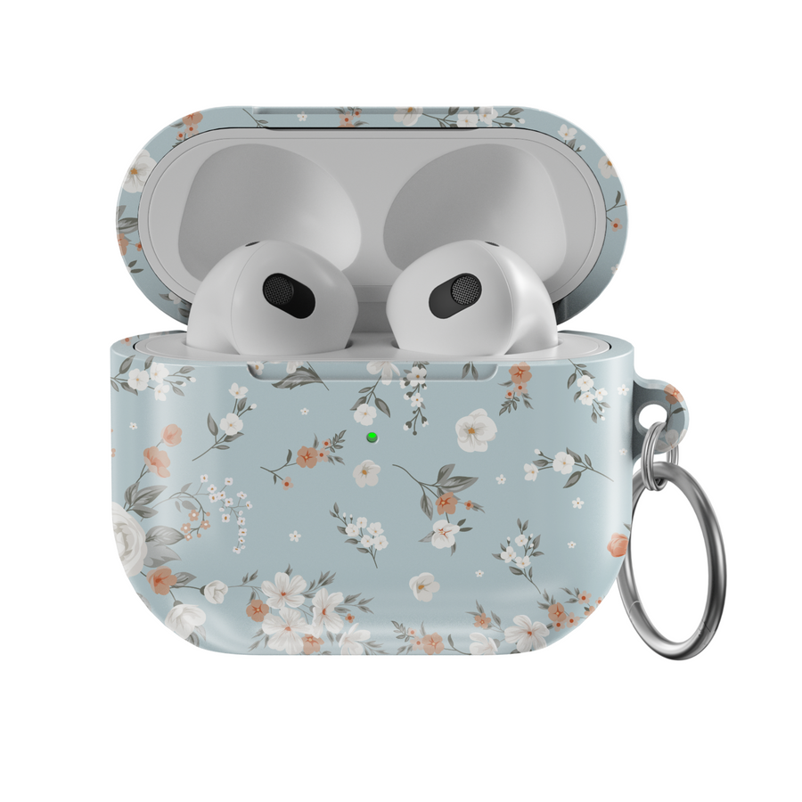 Stylish blue AirPods case with delicate peach and white floral print, featuring a glossy finish and silver keychain ring. A soft, music-inspired accessory for AirPods Pro and AirPods 3.