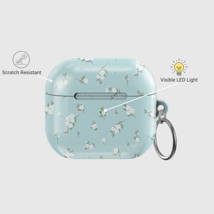 Light blue AirPods case with delicate white floral design and silver keyring, soft minimal aesthetic protective cover for AirPods Pro or AirPods 3.