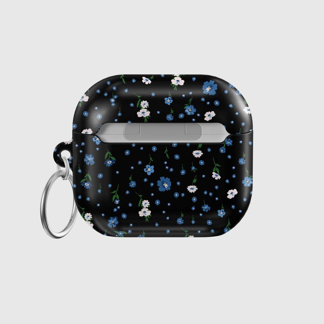 Black AirPods case with tiny blue and white floral print, silver keychain attachment, inspired by indie music vibes and soft aesthetic design for AirPods Pro or AirPods 3.