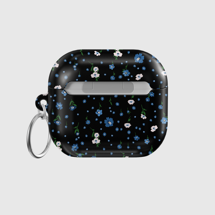 Black AirPods case with tiny blue and white floral print, silver keychain attachment, inspired by indie music vibes and soft aesthetic design for AirPods Pro or AirPods 3.