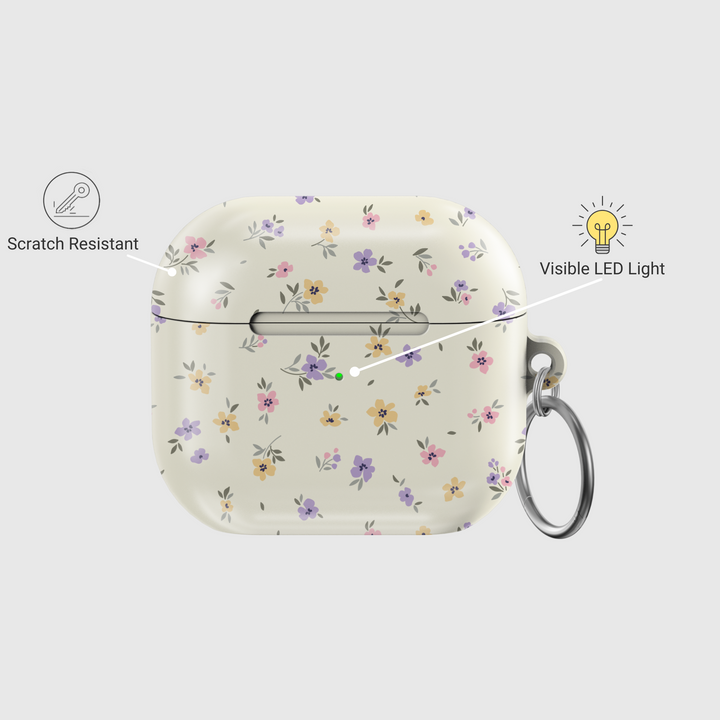 AirPods case with a cream background and tiny pastel floral print in lavender, yellow, and pink, finished with a glossy texture and keychain loop.