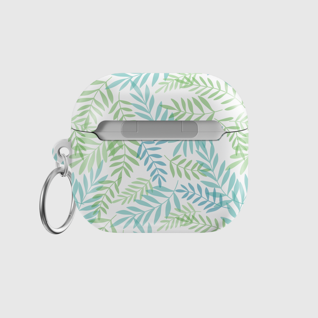 Glossy white AirPods case with green and teal botanical leaf pattern and silver keyring—tropical and nature-inspired accessory.