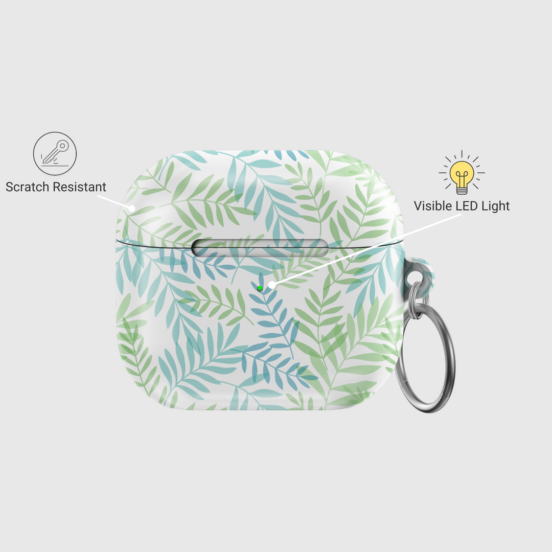Glossy white AirPods case with green and teal botanical leaf pattern and silver keyring—tropical and nature-inspired accessory.