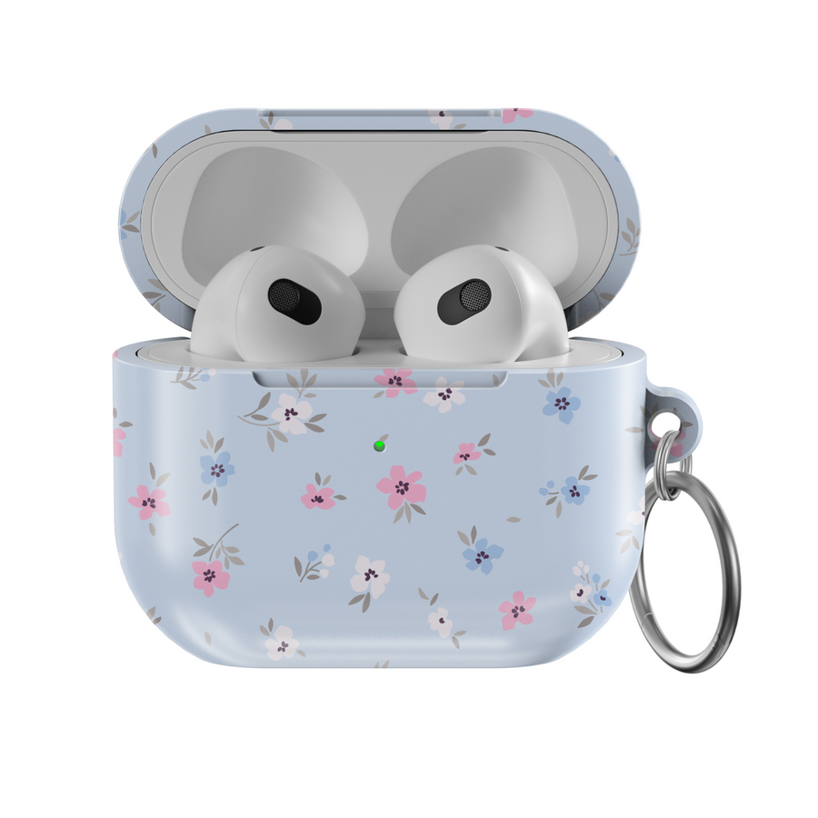 Glossy baby blue AirPods case with delicate pink, white, and blue floral print and silver keychain—pastel aesthetic and soft feminine design