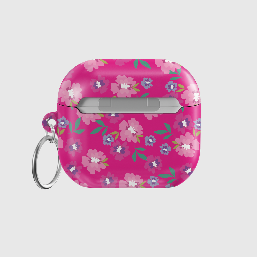 Glossy hot pink AirPods case with colorful floral print featuring white, purple, and pink flowers, includes a silver keychain ring.