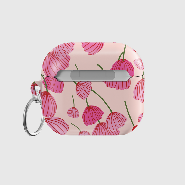 AirPods case with blush pink background featuring stylized red and pink poppy flower design, glossy finish with silver keychain ring.