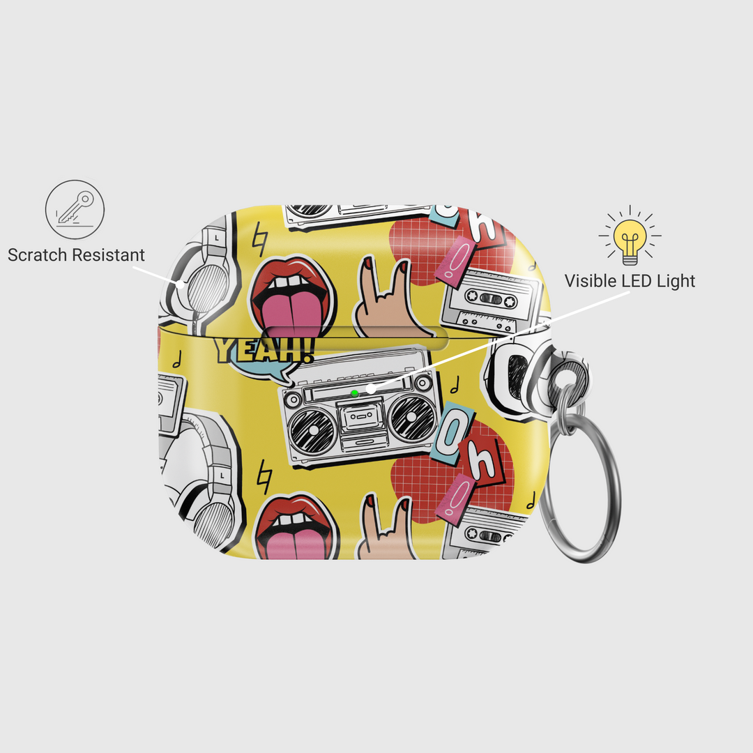 Yellow AirPods case with pop art design featuring boombox, cassette tape, tongue-out lips, headphones, and retro icons in bold cartoon style with a glossy finish and keychain.