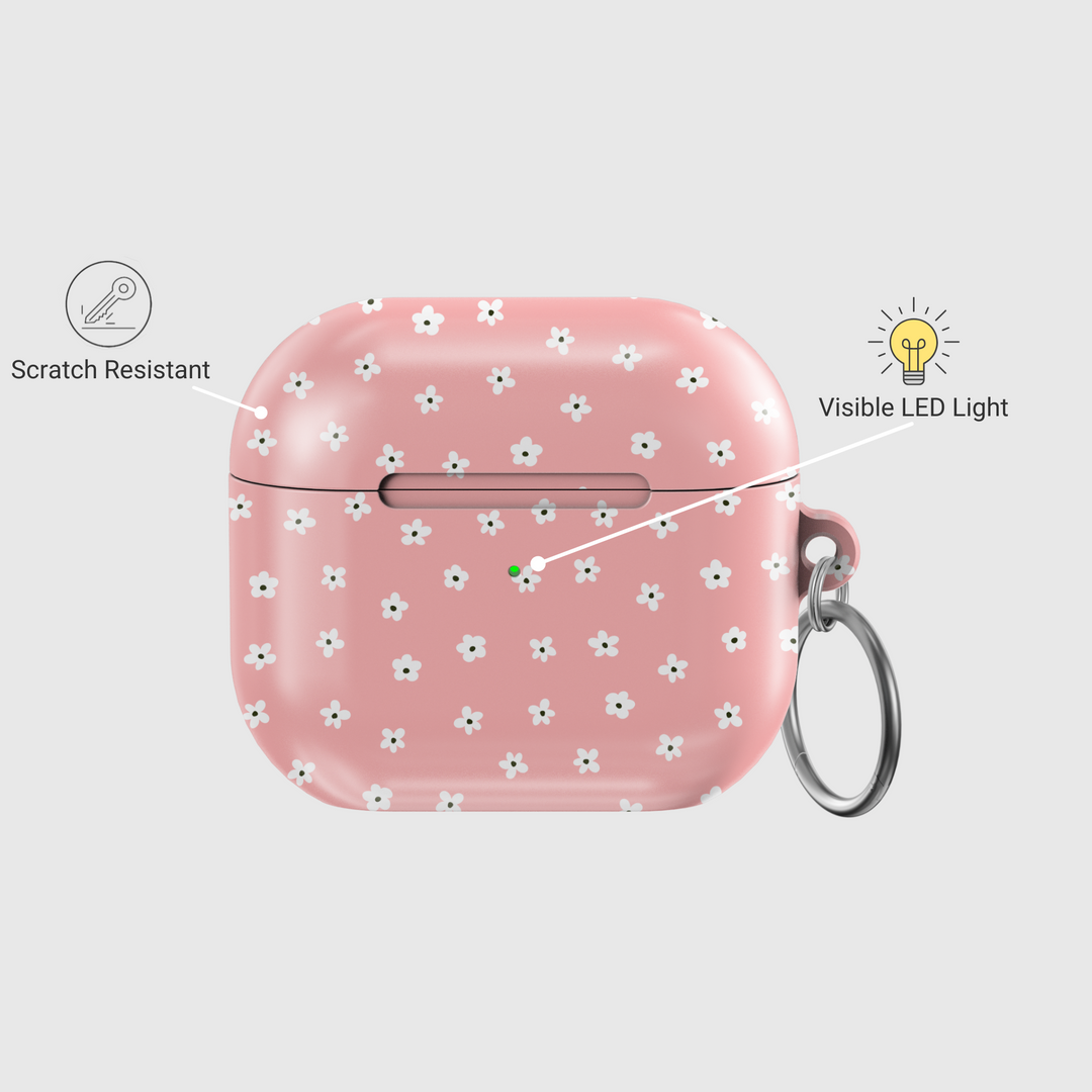 Soft pink AirPods case featuring a pattern of tiny white flowers with a glossy finish and silver keychain, perfect for a girly, floral aesthetic.