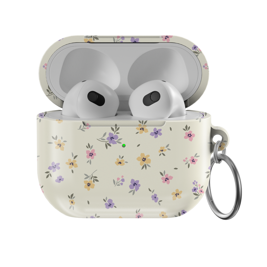 AirPods case with a cream background and tiny pastel floral print in lavender, yellow, and pink, finished with a glossy texture and keychain loop.