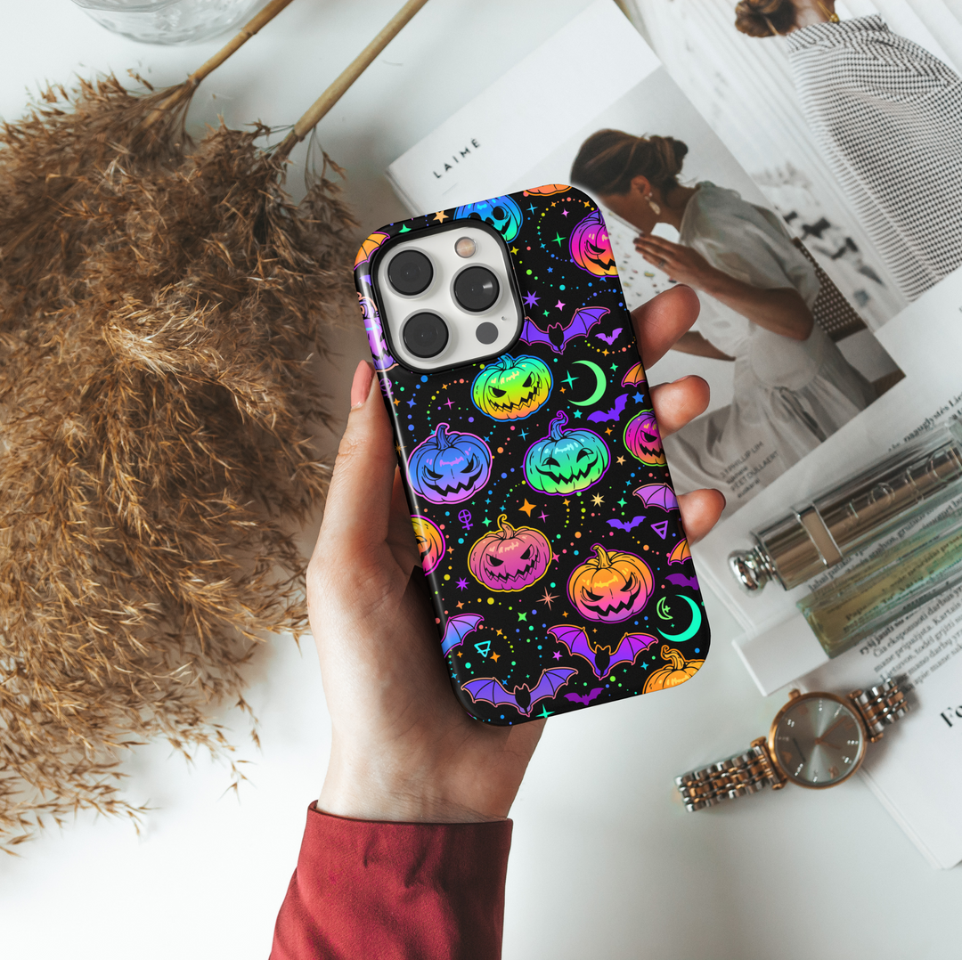Colorful neon Halloween iPhone case with glowing rainbow pumpkins, bats, stars, moons, and spooky symbols on a black background. Features aesthetic spooky season vibes with vibrant jack-o'-lanterns, creepy bats, and a magical night sky design. Perfect for iPhone 16 Pro Max, 15, 14, and 13.