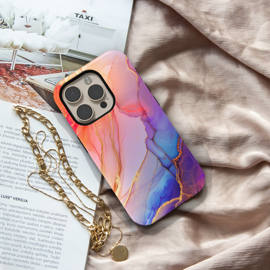 Elegant blush pink and violet marble swirl iPhone 16 MagSafe case with gold accents and fluid abstract design.