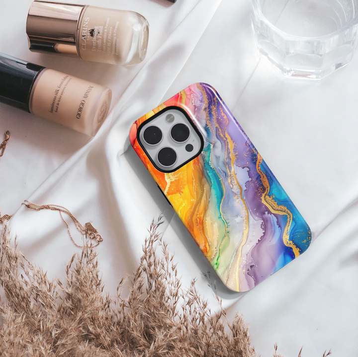 Colorful rainbow marble swirl iPhone 16 MagSafe case with fluid abstract art in yellow, orange, blue, green, and purple hues with gold accents.