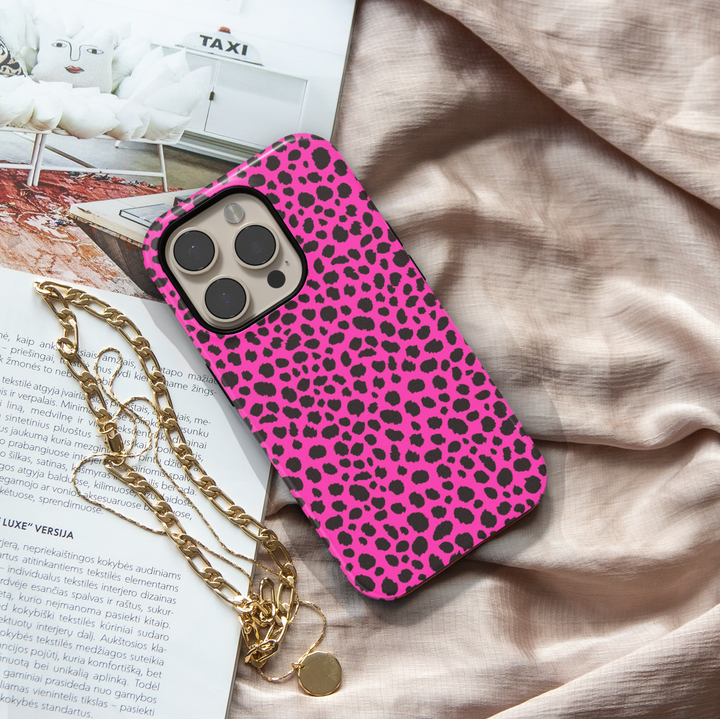 Hot pink leopard print iPhone case with bold black animal spots, designed for iPhone 16 series and MagSafe compatible, featuring a girly wild aesthetic.