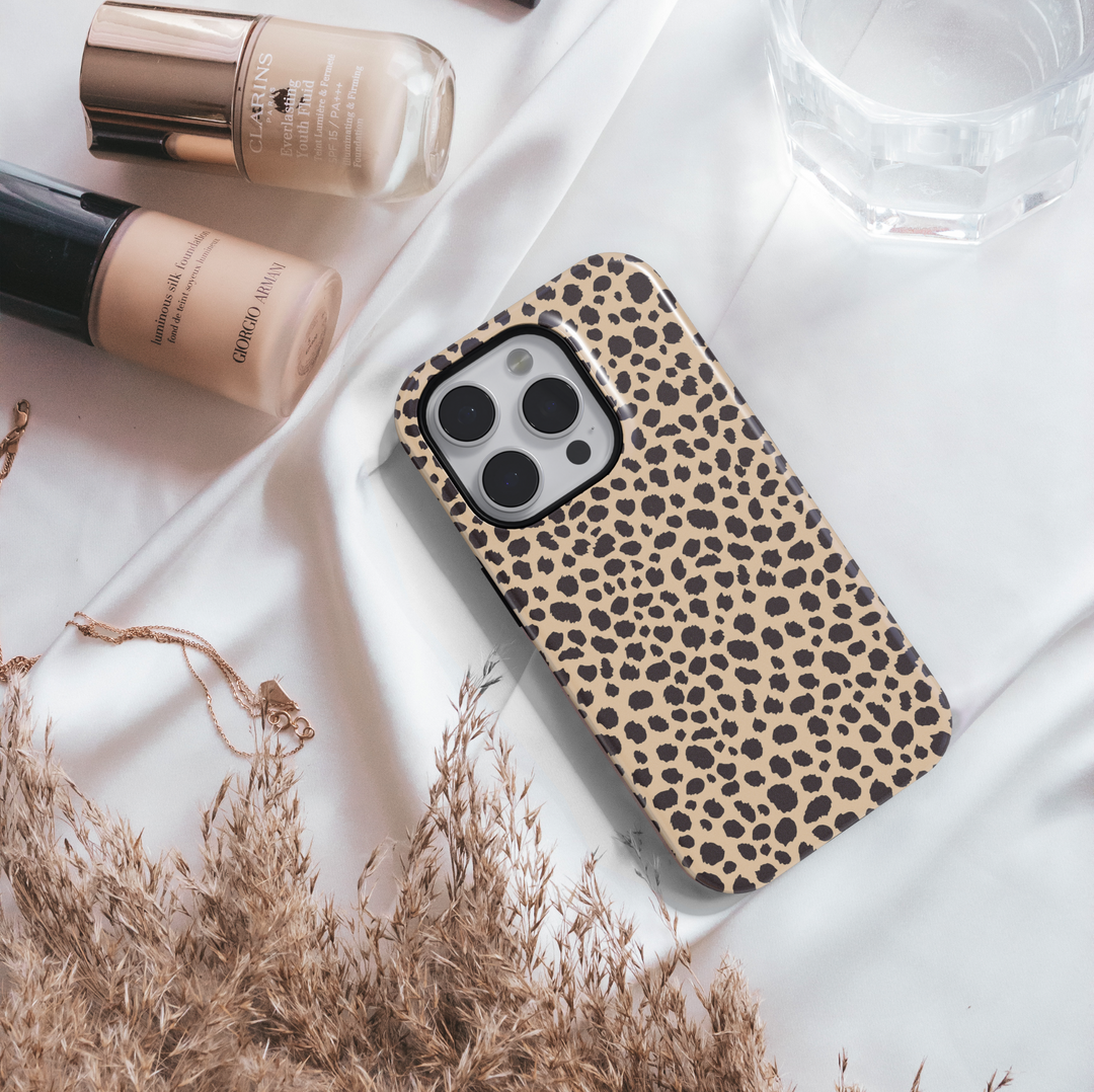 Leopard print iPhone case with bold black animal spots on a tan background, designed for iPhone 16 series with MagSafe compatibility.