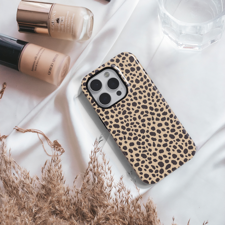 Leopard print iPhone case with bold black animal spots on a tan background, designed for iPhone 16 series with MagSafe compatibility.