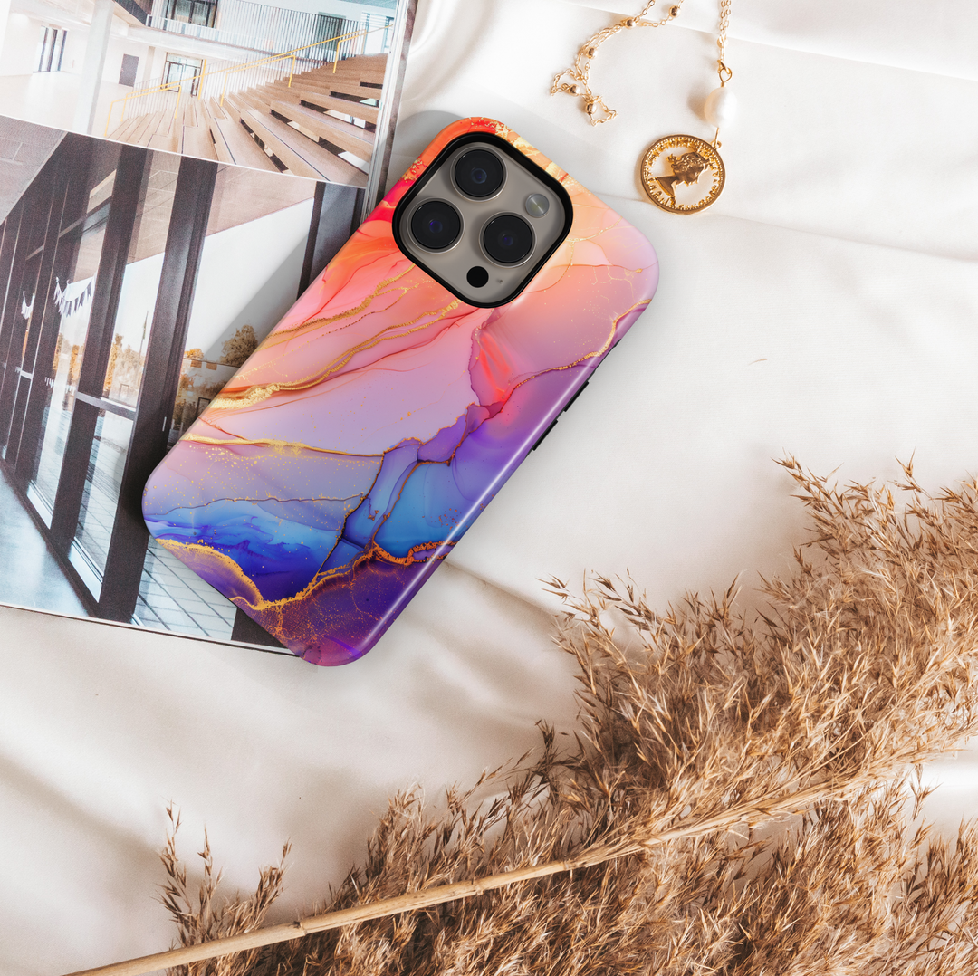 Elegant blush pink and violet marble swirl iPhone 16 MagSafe case with gold accents and fluid abstract design.