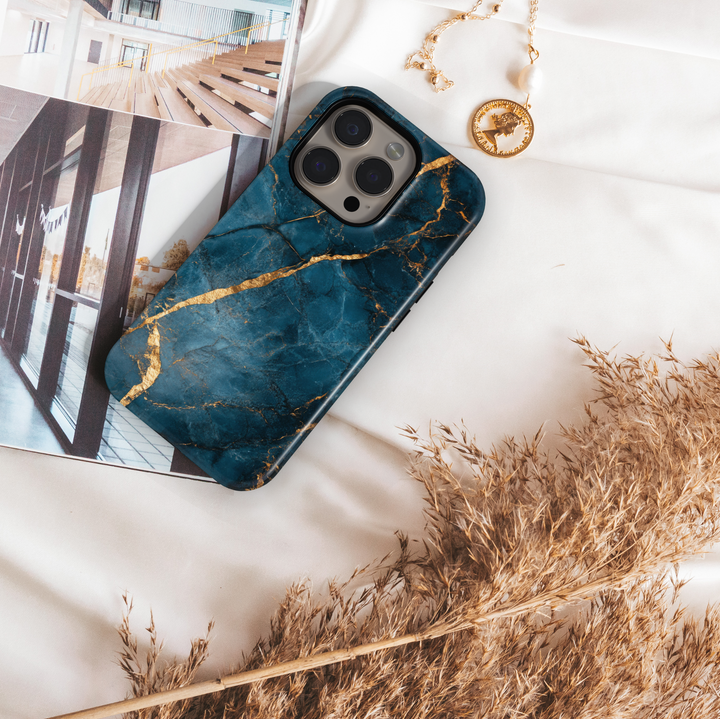 Elegant iPhone case with deep blue marble texture and gold vein detailing; MagSafe-compatible tough case for iPhone 16.