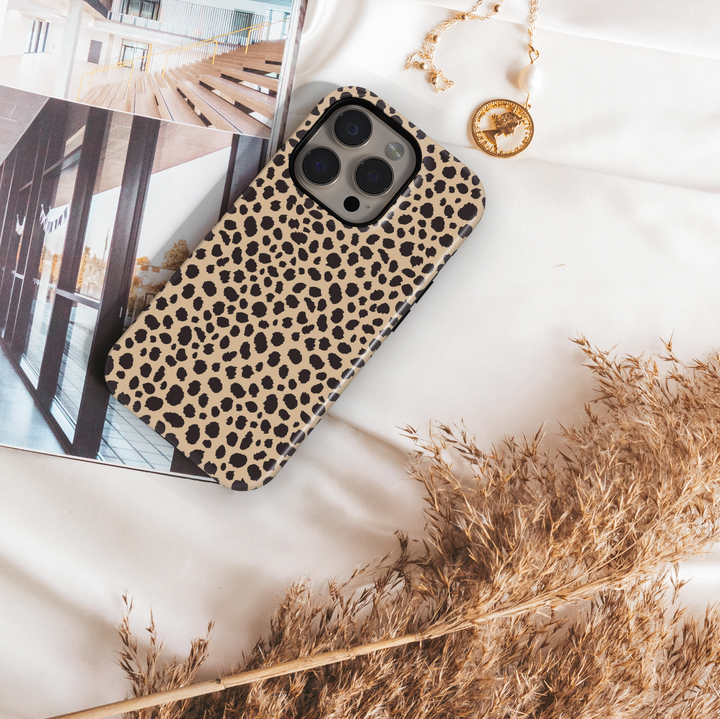 Leopard print iPhone case with bold black animal spots on a tan background, designed for iPhone 16 series with MagSafe compatibility.