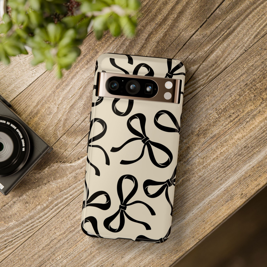 Glossy beige Google Pixel case with large black bow pattern – protective and stylish cover compatible with Pixel 8, Pixel 8 Pro, Pixel 9 Pro XL