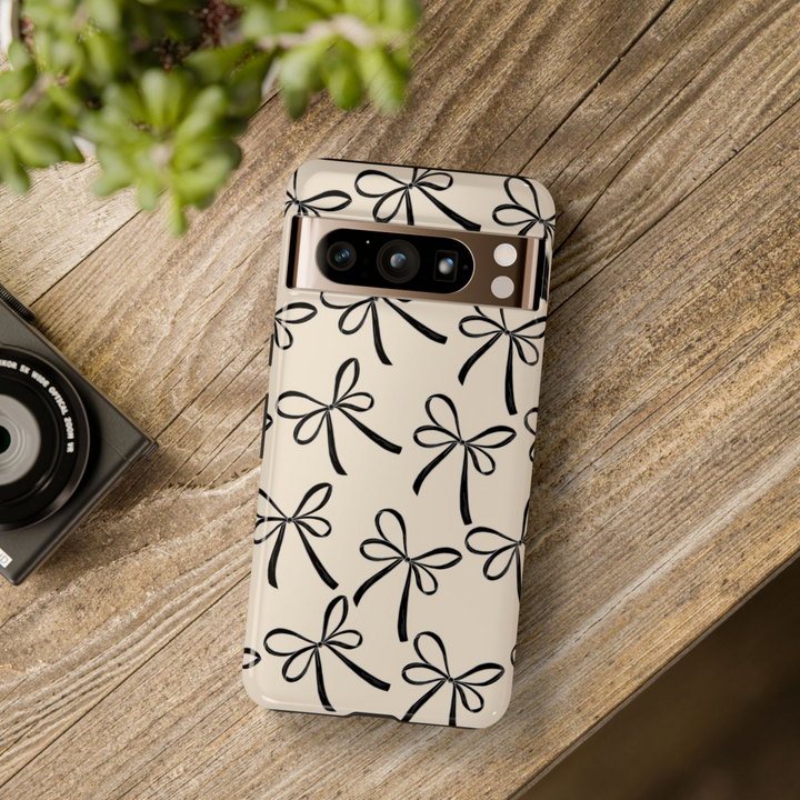 Minimalist beige Google Pixel tough phone case with black hand-drawn bow pattern, compatible with Pixel 8, Pixel 8 Pro, Pixel 9 Pro XL