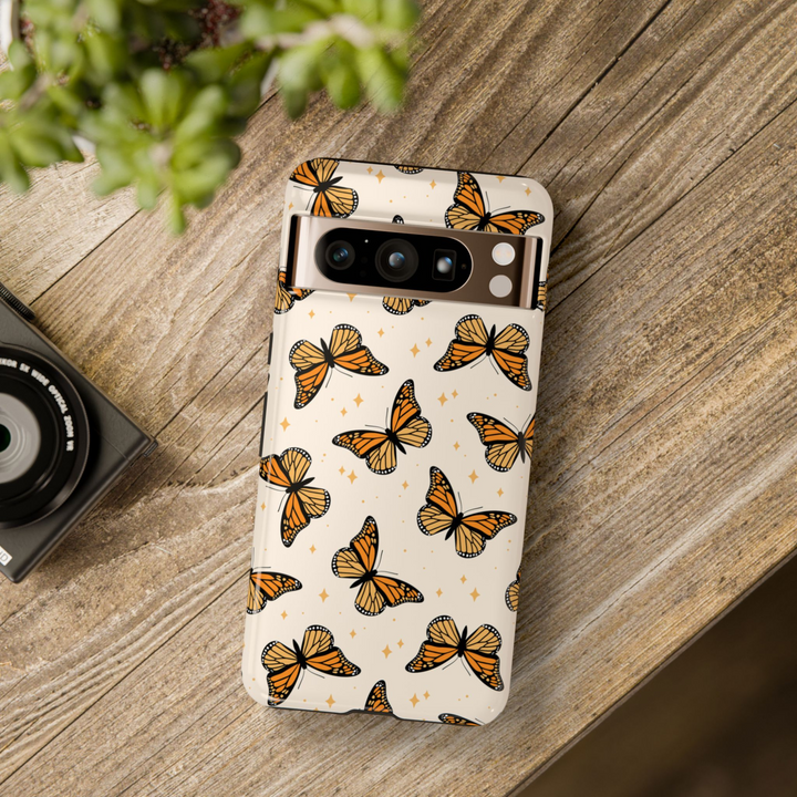Google Pixel phone case featuring orange monarch butterflies on a cream background with sparkly star accents