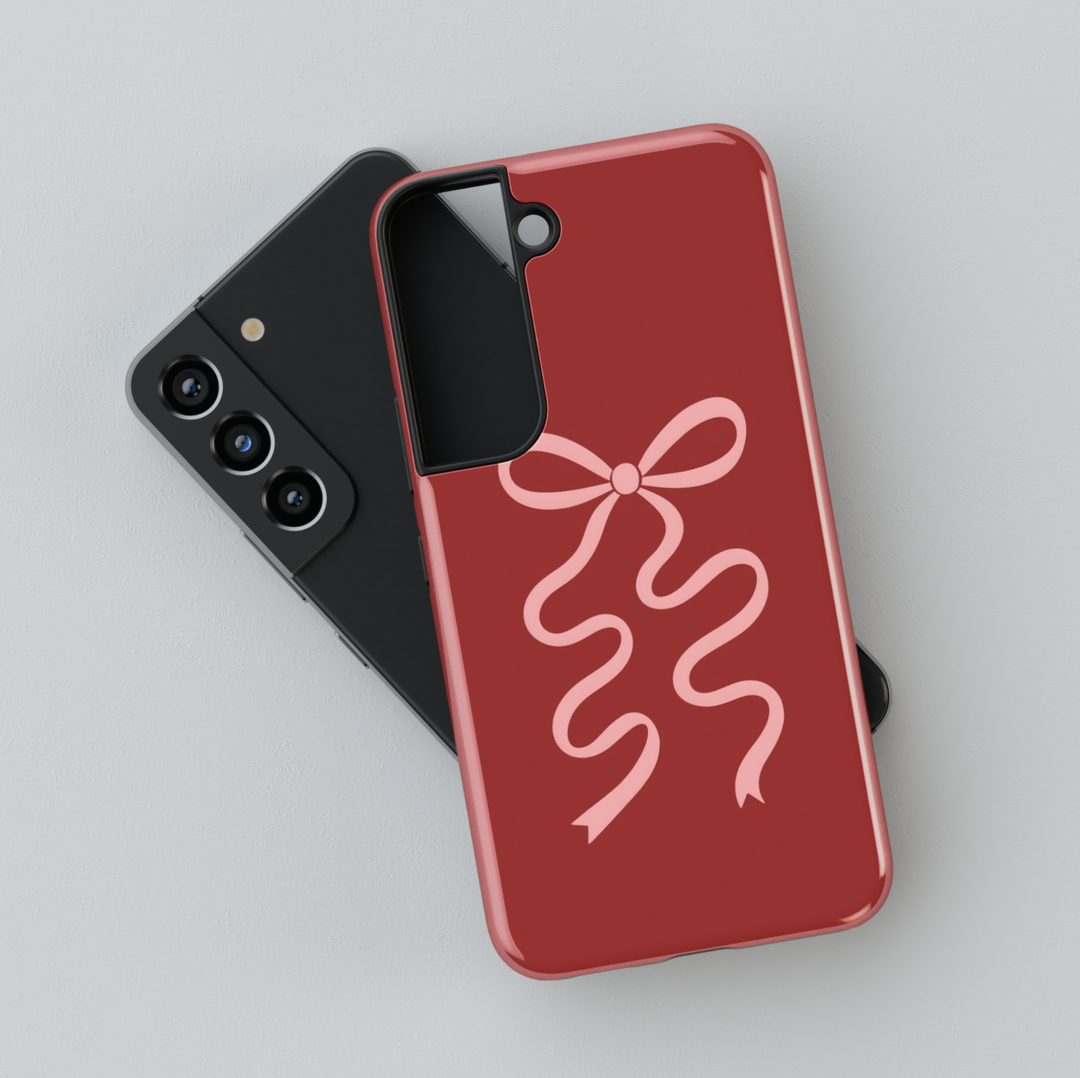 Deep red Samsung Galaxy phone case with soft pink ribbon bow – compatible with Galaxy S24 Ultra, S25, S24 FE. Elegant coquette aesthetic case for women.