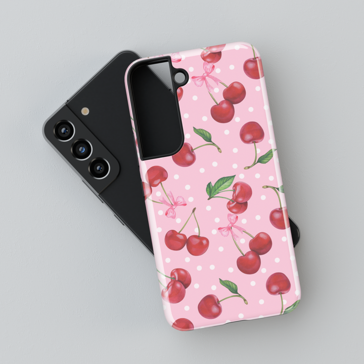 Cute Samsung Galaxy case with pink background, red cherry and white polka dot pattern – fits Galaxy S24 Ultra, S25, S24 FE. Girly cherry design with leaves and bow accents.