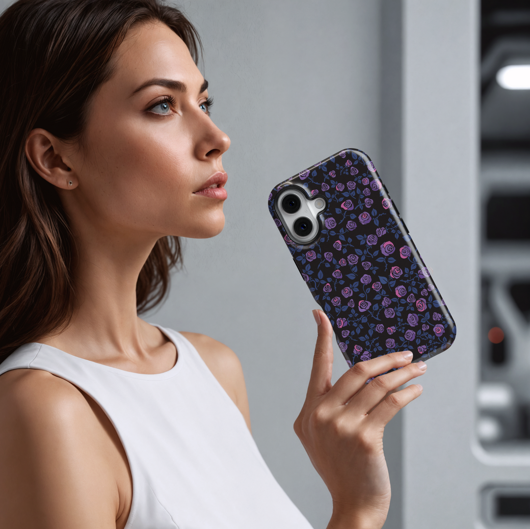 iPhone case with a dark black background covered in a seamless pattern of purple and pink roses and blue leaves, creating a moody, romantic aesthetic.