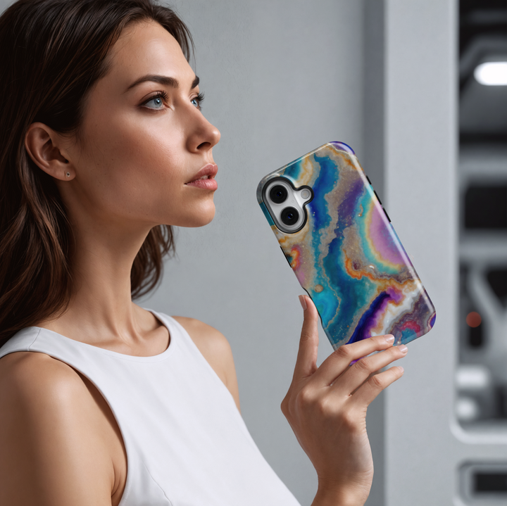 Tough iPhone 16 MagSafe case featuring a colorful geode swirl pattern in turquoise, purple, gold, and white with a glossy finish.