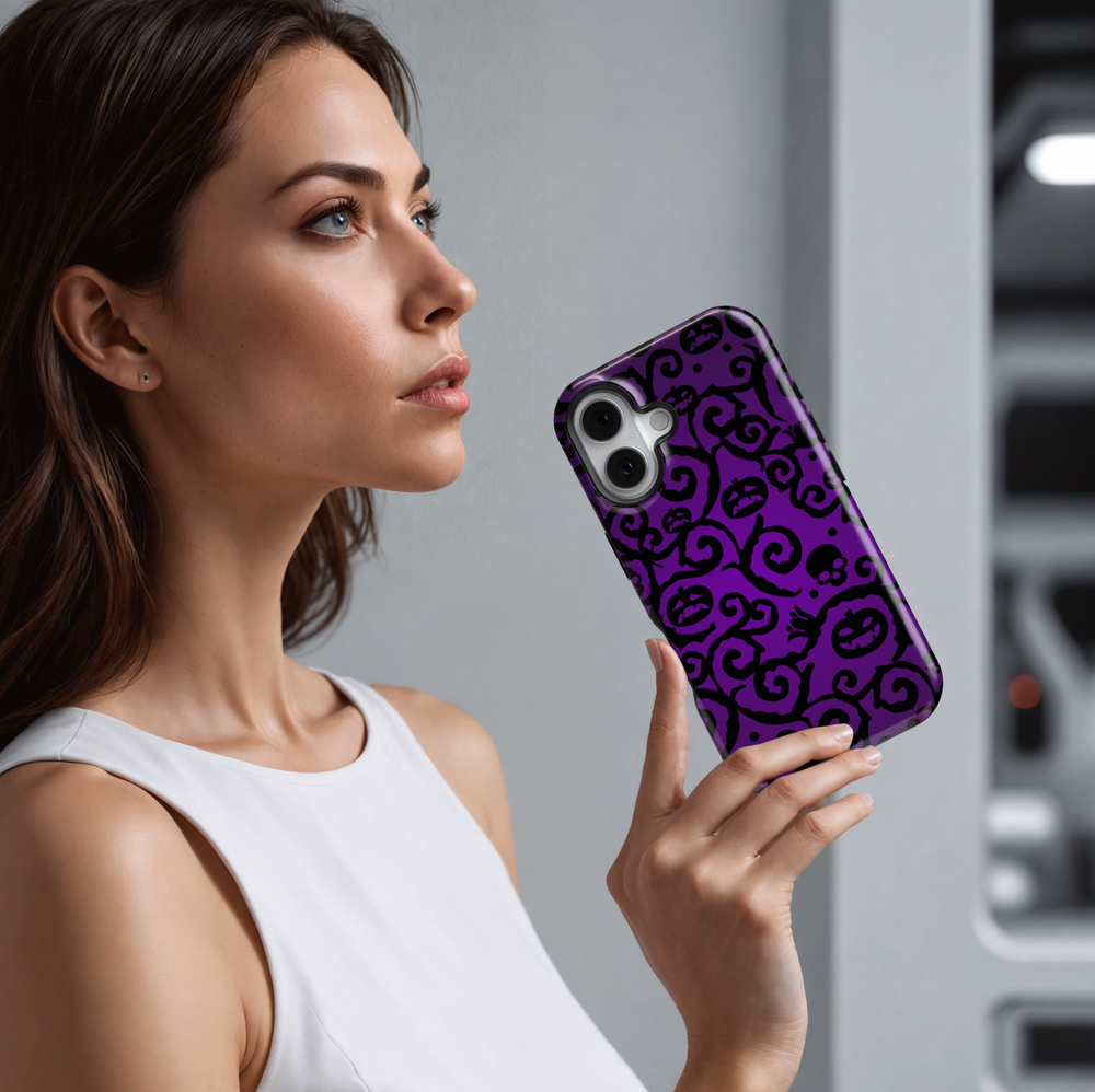 Purple iPhone case with swirling black Halloween vines, spooky jack-o'-lantern faces, skulls, and dark gothic pattern. Perfect for Halloween season aesthetic