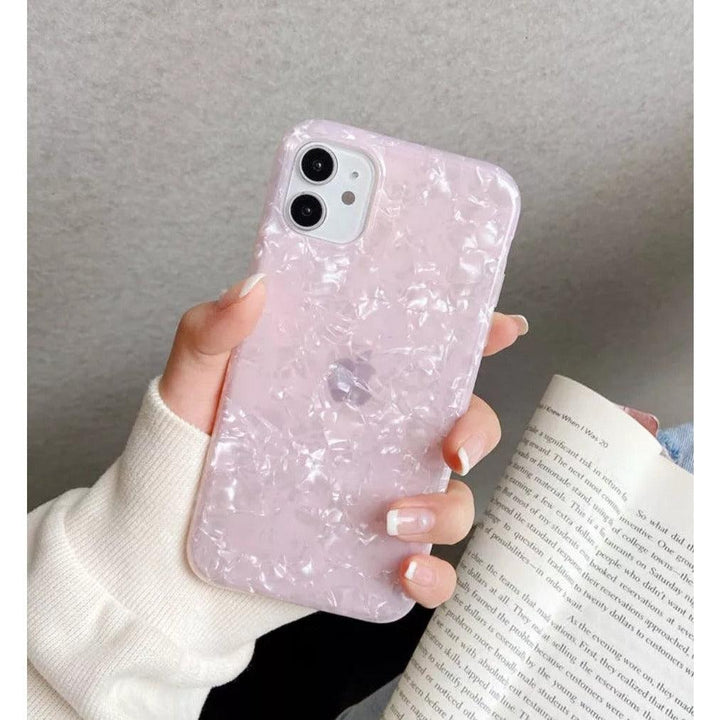 Glossy pearl pink iPhone case with a luxurious shimmer shell texture, designed for a stylish and protective fit.