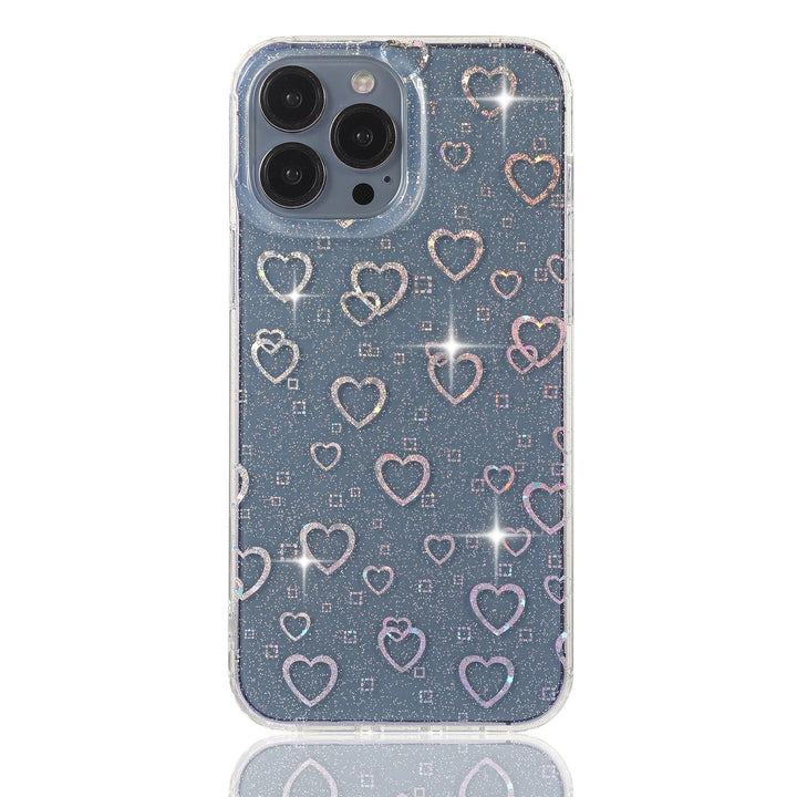 Stylish clear iPhone case featuring a dazzling holographic heart pattern with glitter details. The case catches the light beautifully, creating a mesmerizing sparkle effect. Designed for both style and protection, this case keeps your phone safe while adding a trendy and eye-catching touch. Perfect for those who love a little shimmer in their everyday accessories.