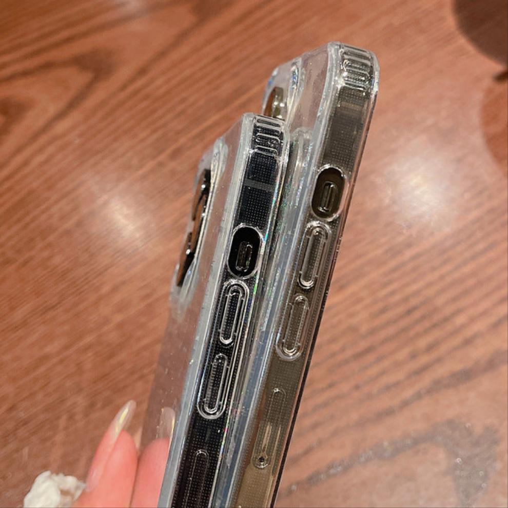 Stylish clear iPhone case featuring a dazzling holographic heart pattern with glitter details. The case catches the light beautifully, creating a mesmerizing sparkle effect. Designed for both style and protection, this case keeps your phone safe while adding a trendy and eye-catching touch. Perfect for those who love a little shimmer in their everyday accessories.