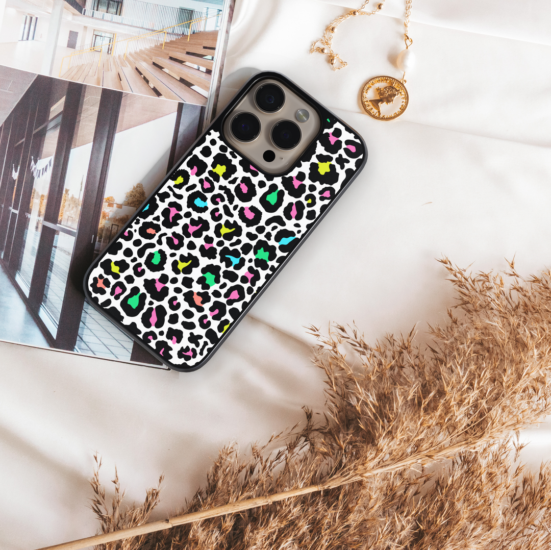 iPhone case with colorful neon leopard print design in pink, green, yellow, and teal on a white background – trendy girly protective phone cover.