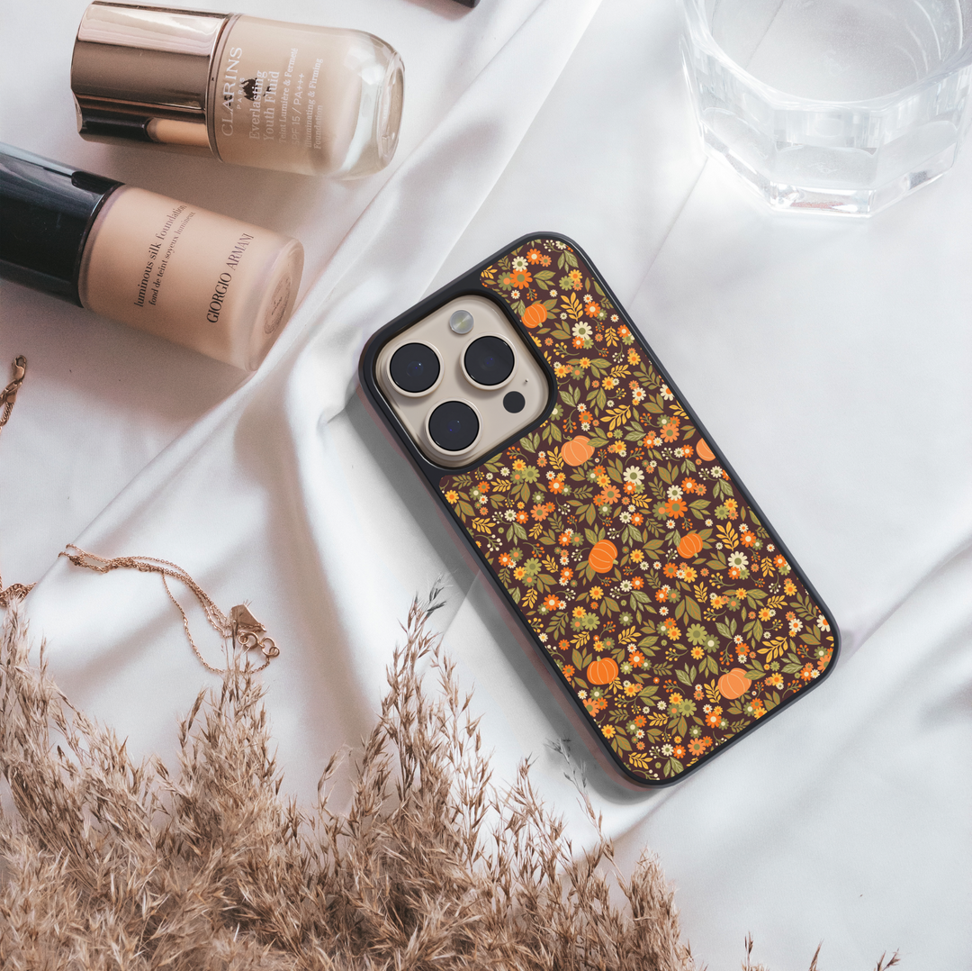 iPhone case with chic pumpkin and floral pattern in warm autumn tones – girly fall aesthetic design.