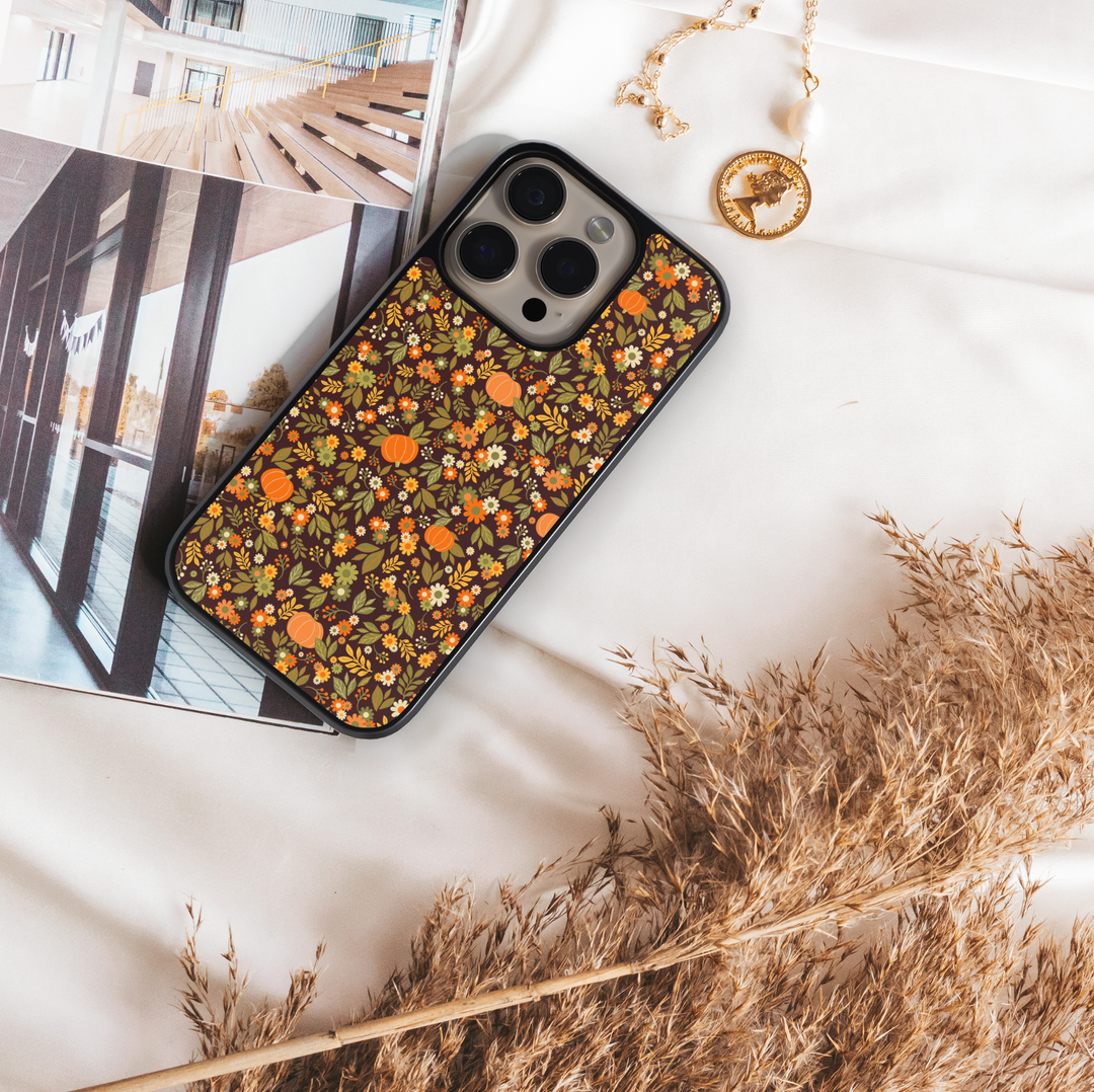 iPhone case with chic pumpkin and floral pattern in warm autumn tones – girly fall aesthetic design.