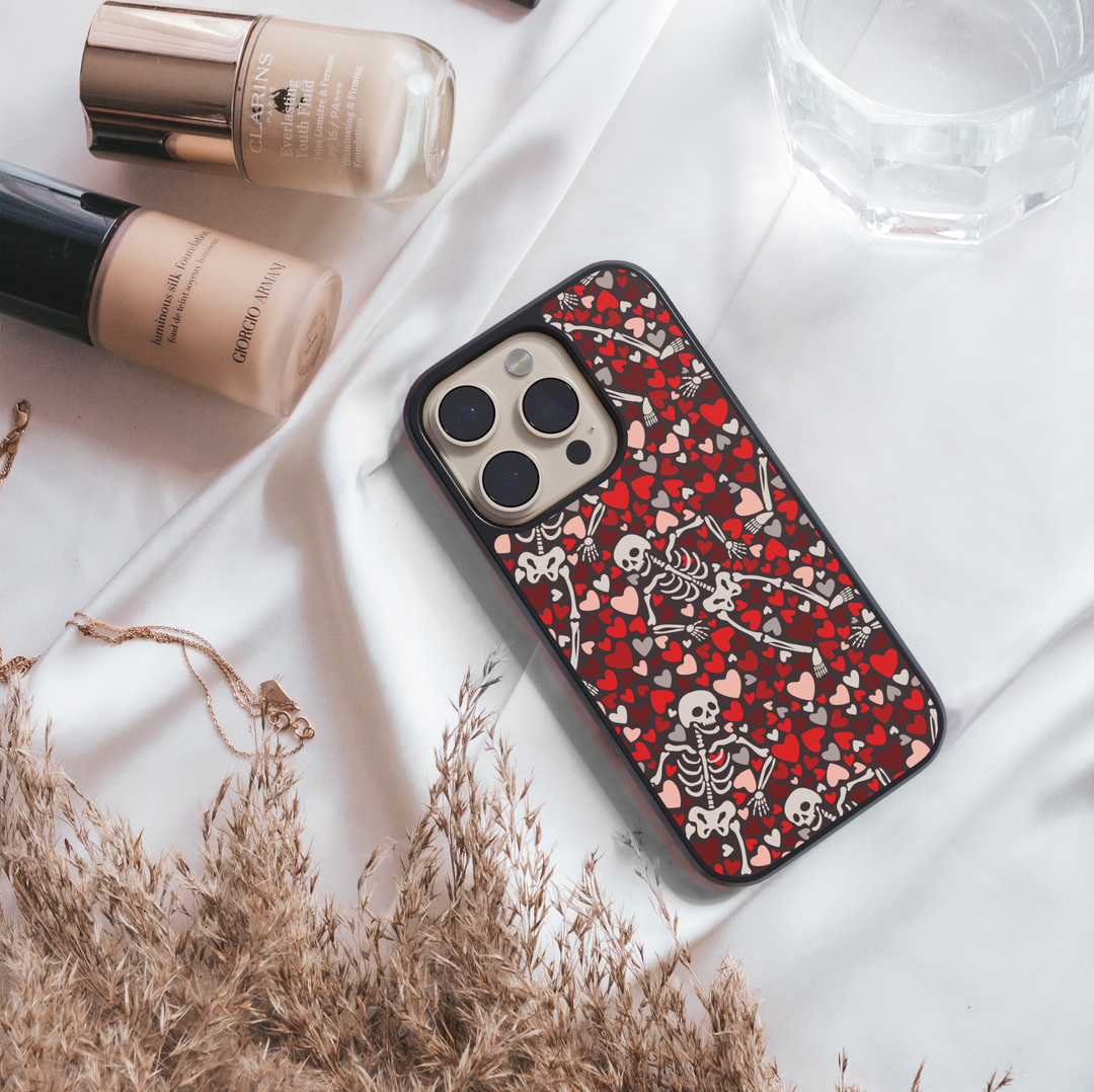 Hearts Skeleton iPhone Case, Halloween iPhone cover with spooky skeletons and pumpkin heads, cute gothic phone case with black background, protective fall phone case, stylish skeleton iPhone cover