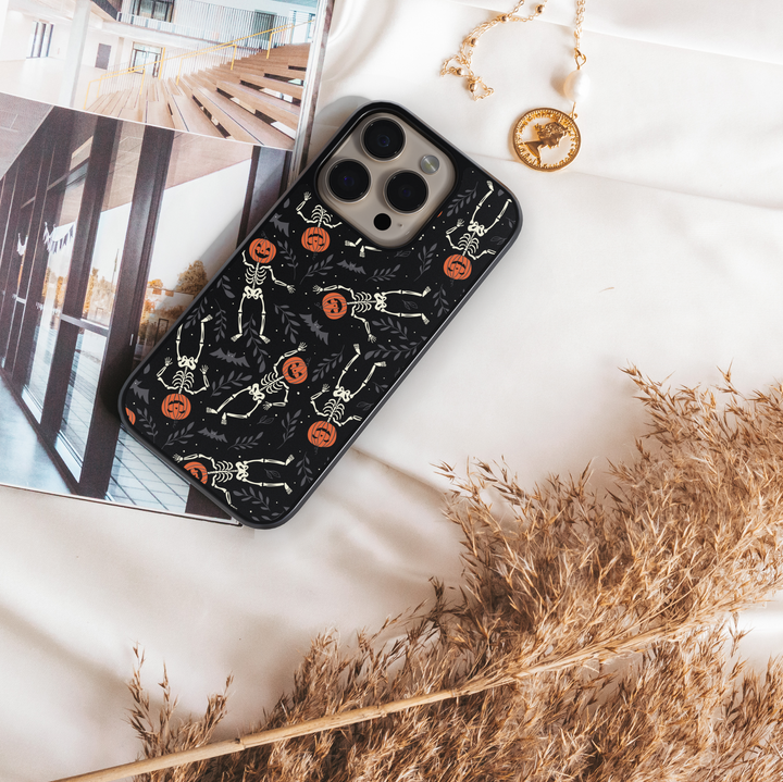 Pumpkin Skeleton iPhone Case, Halloween iPhone cover with spooky skeletons and pumpkin heads, cute gothic phone case with black background, protective fall phone case, stylish skeleton iPhone cover