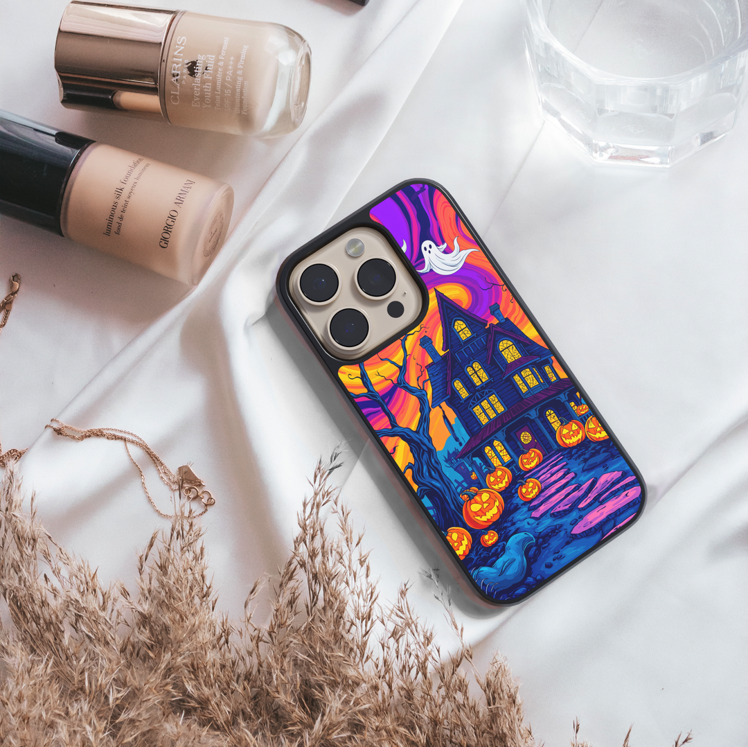 Halloween haunted house phone case with glowing pumpkins, ghosts, bats, and colorful night sky – spooky protective iPhone and Samsung Galaxy cover for Halloween aesthetic