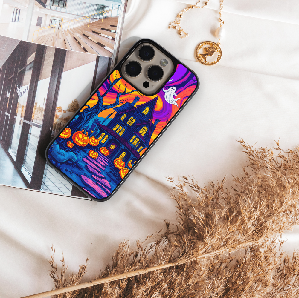 Halloween haunted house phone case with glowing pumpkins, ghosts, bats, and colorful night sky – spooky protective iPhone and Samsung Galaxy cover for Halloween aesthetic